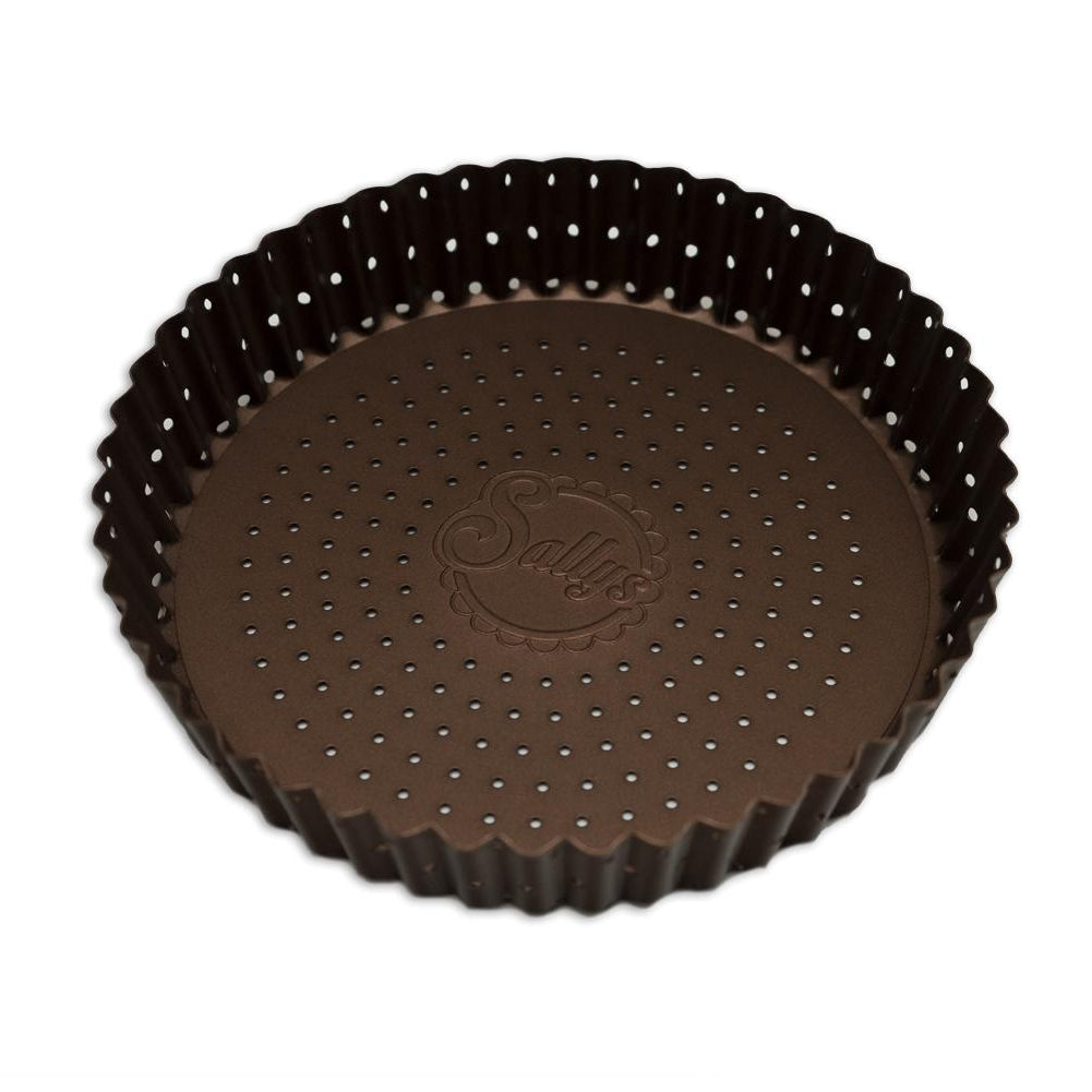 Eine kupferfarbene Tarteform mit perforiertem Boden