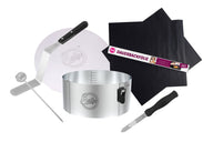 Ein Tortenring, ein Tortenretter, ein schwarzes Backformmesser, eine Dauerbackfolie, eine Winkelpalette und ein Kuchentester